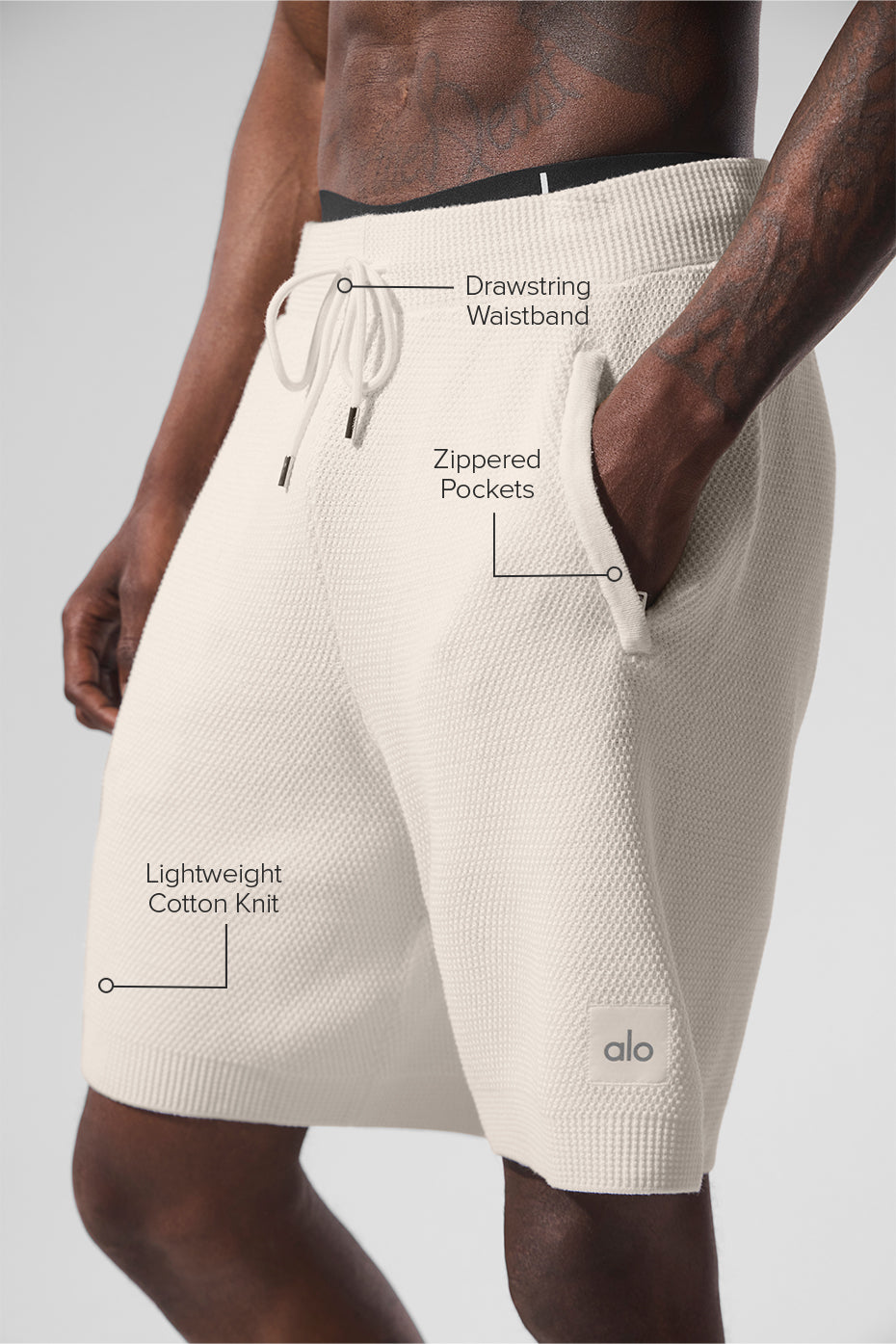 Model wearing ivory sweat shorts paired with a casual top
