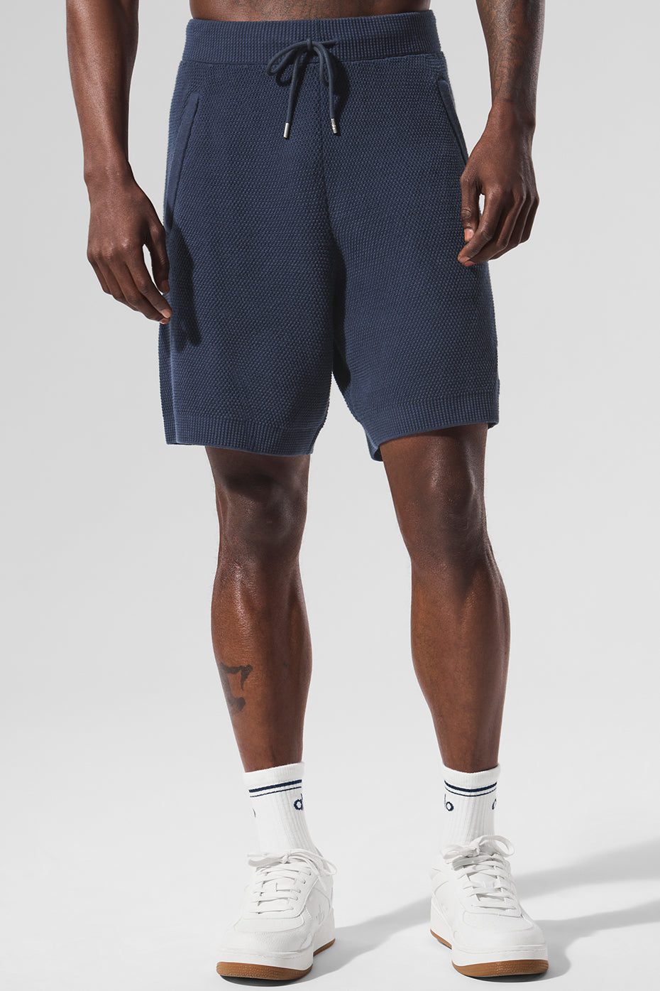 Front view of men's navy cotton knit shorts, styled casually.