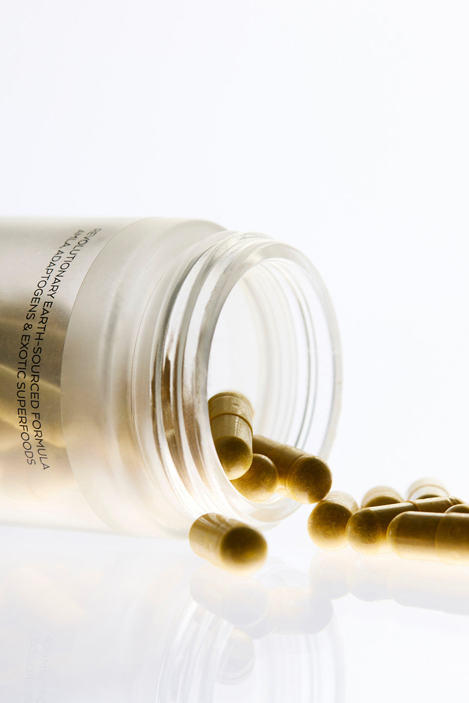 Vegan multivitamin capsules displayed with fresh fruits and vegetables.