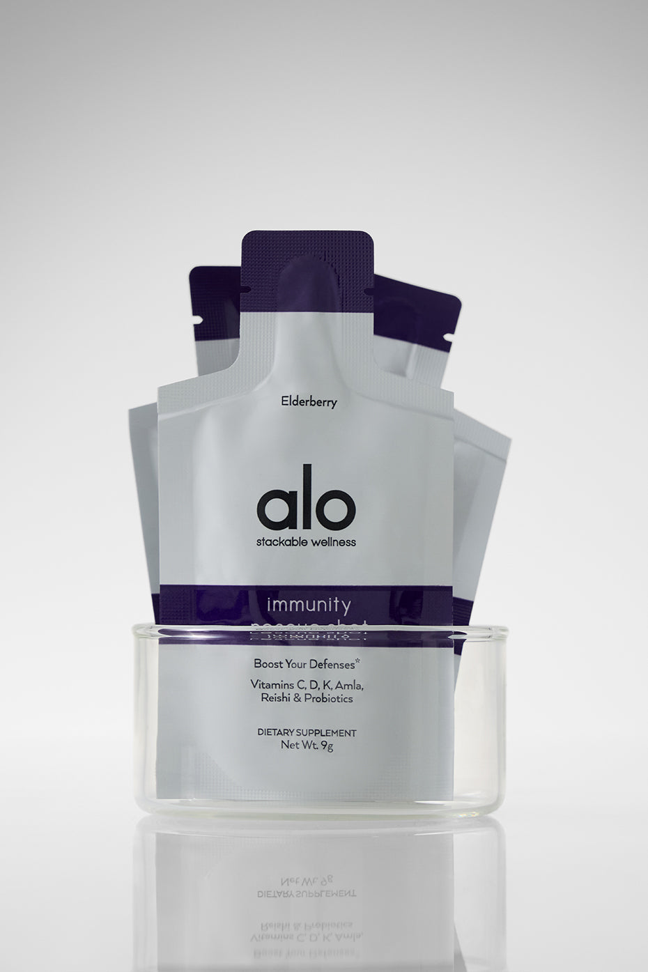 A hand holding an elderberry shot sachet, perfect for on-the-go health.