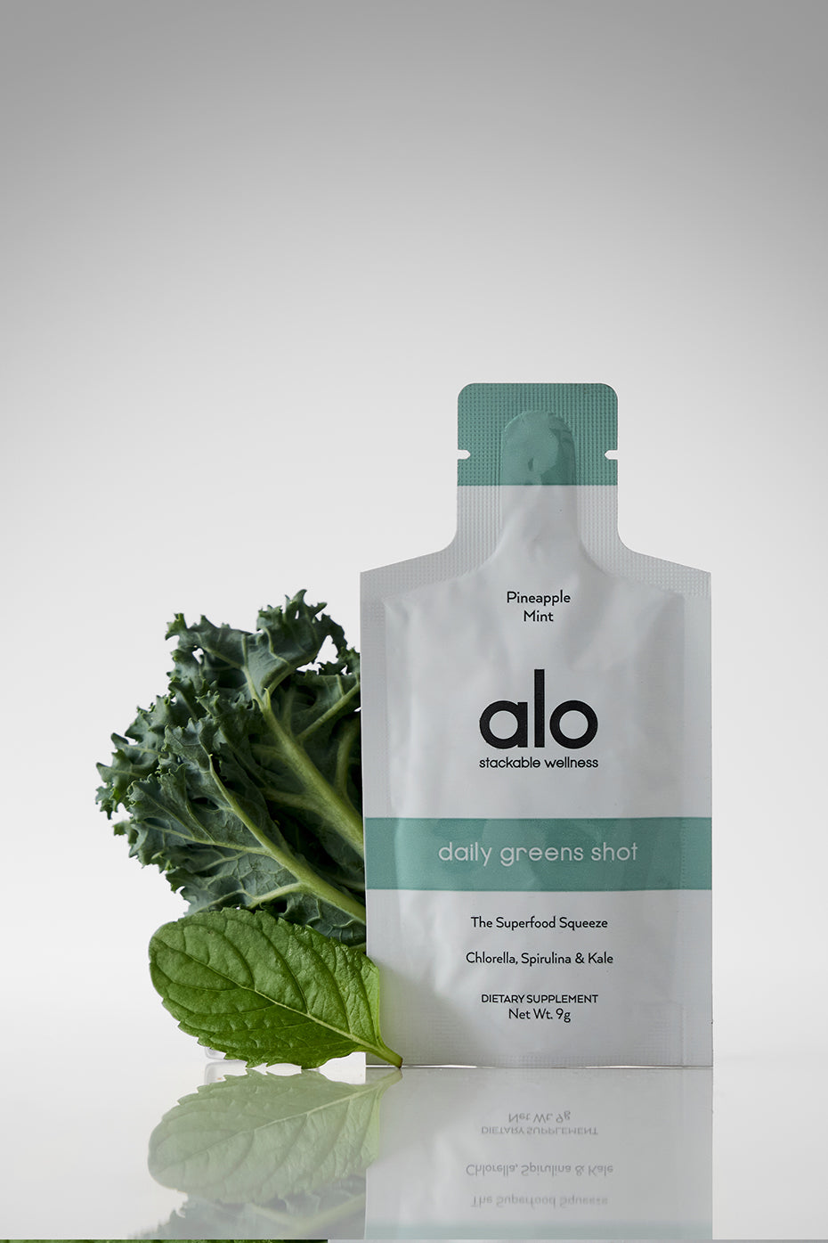 Chlorella and spirulina blend being poured into a reusable water bottle for on-the-go nutrition