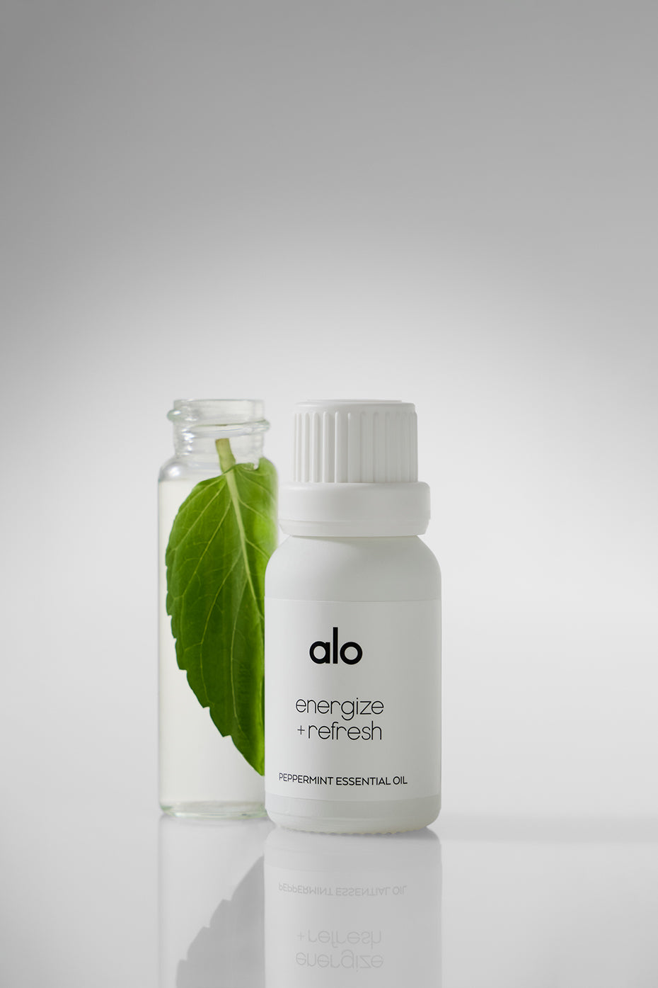Revive Peppermint Essential Oil bottle displayed on a wooden table.