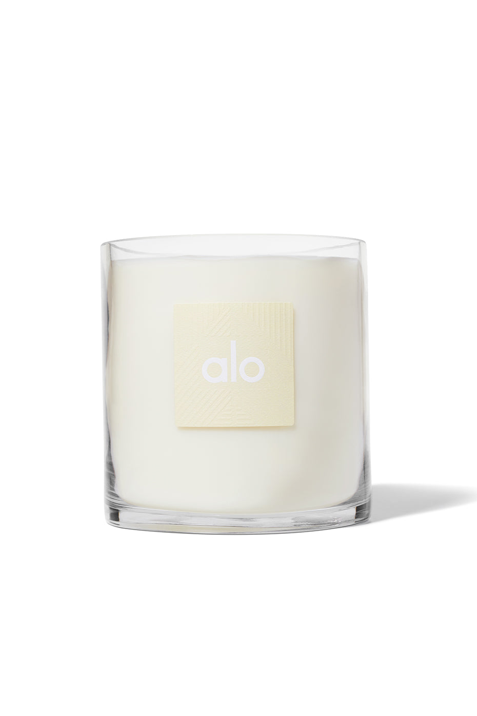 ALO Luxe Santal Candle in a cozy living room setting.