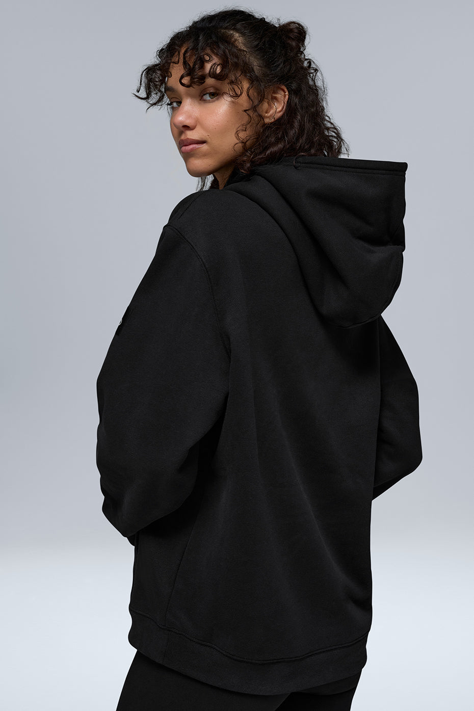 Side angle of heavyweight zip up hoodie, highlighting oversized fit and sleeve cuffs.