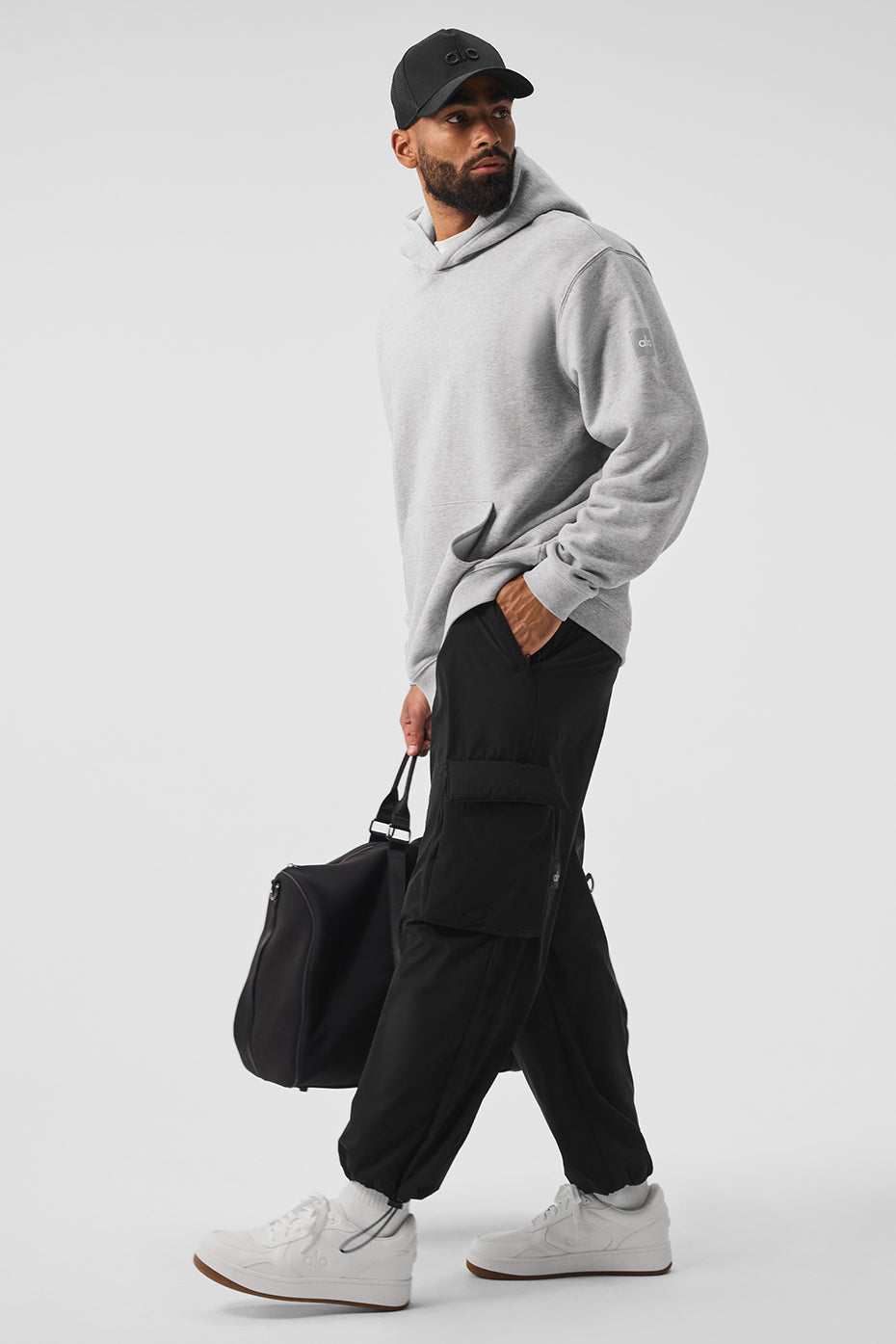 Man wearing oversized zip up hoodie on urban street, hands in pocket