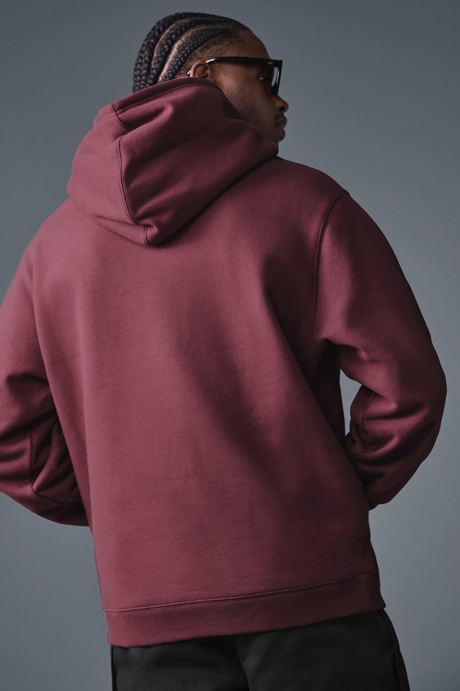 Model wearing unisex hoodie with structured hood, urban backdrop