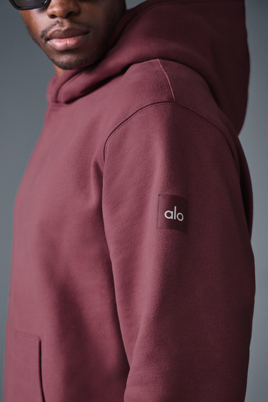 Model wearing unisex hoodie with structured hood, urban backdrop