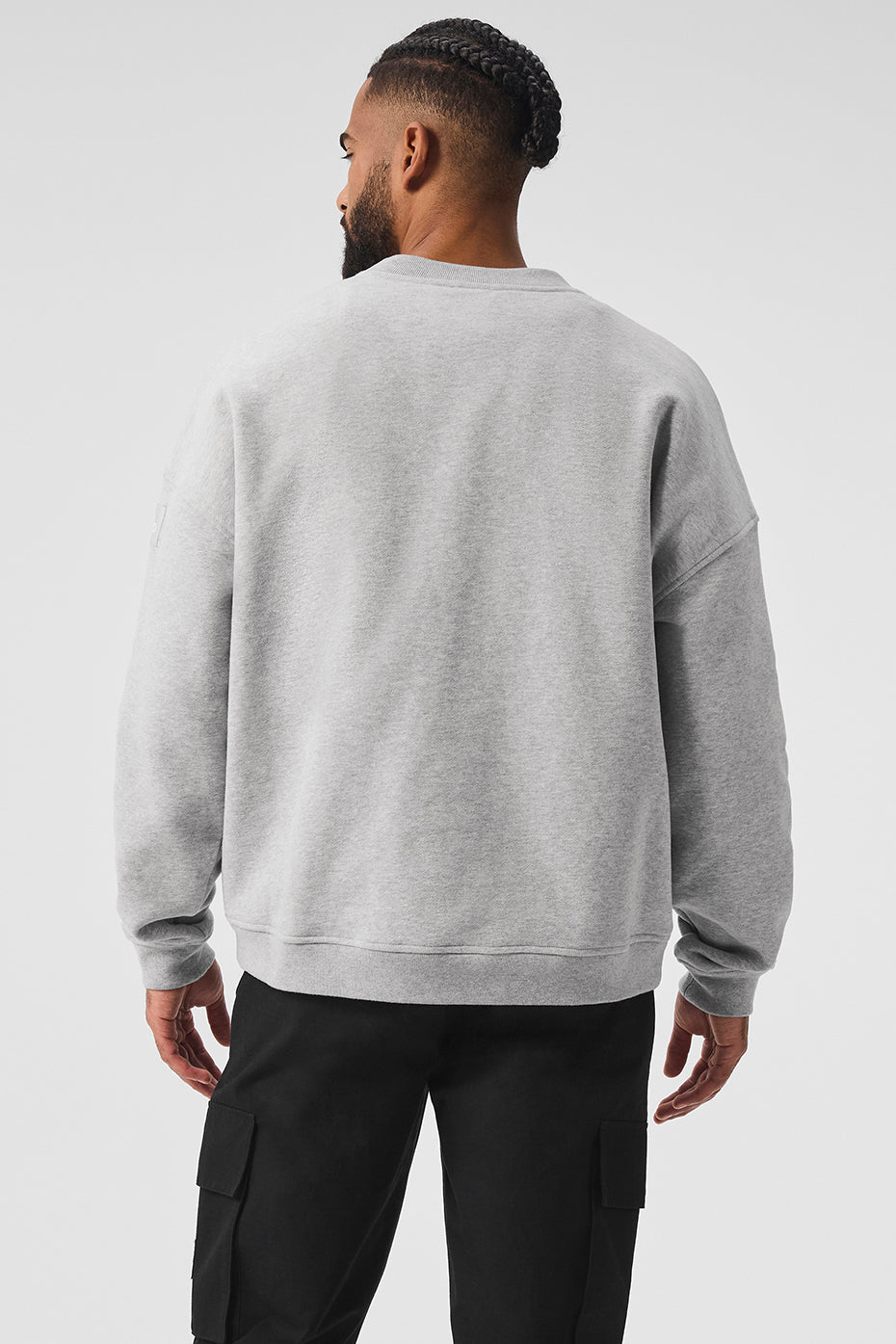 Side view showcasing the dropped shoulder design of the black crew neck pullover.