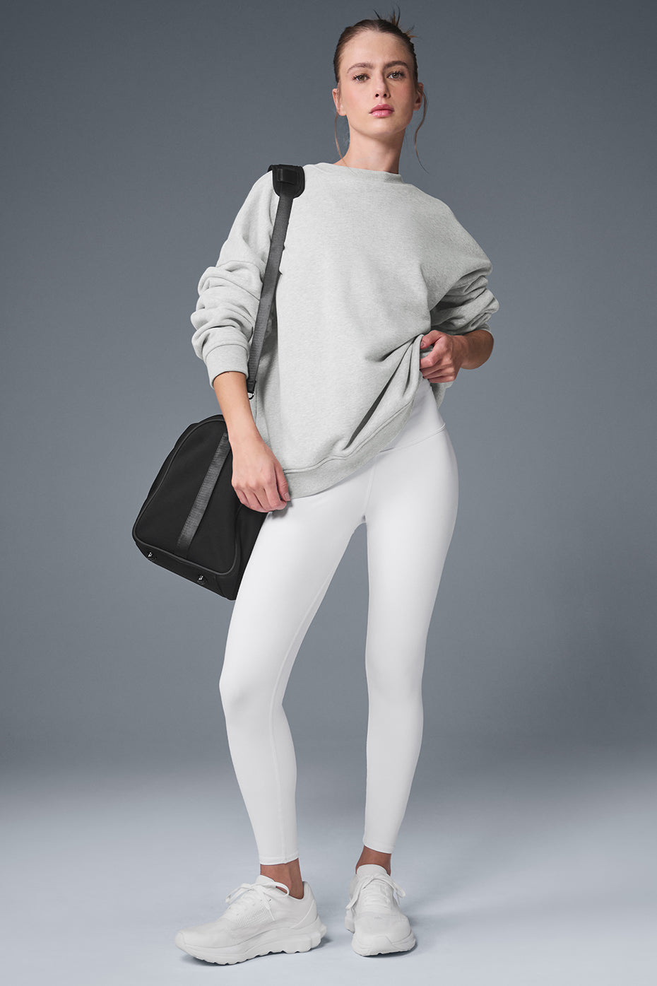 Front view of black crew neck pullover styled with urban streetwear accessories