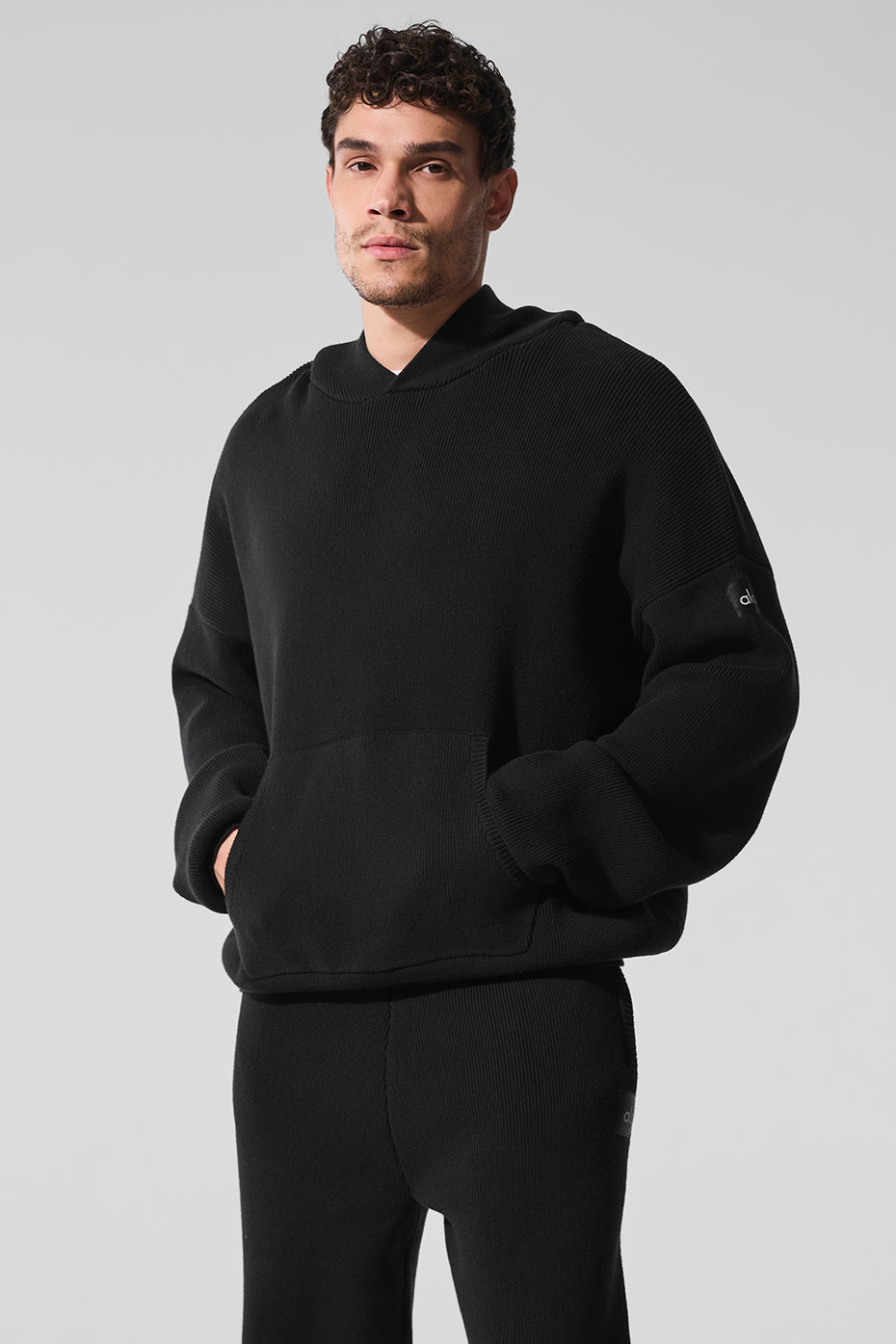 Close-up of the ribbed hem and cuffs on the black hoodie for a snug fit