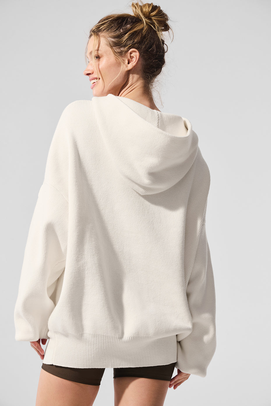 Model wearing the cozy hooded sweater in a relaxed outdoor setting