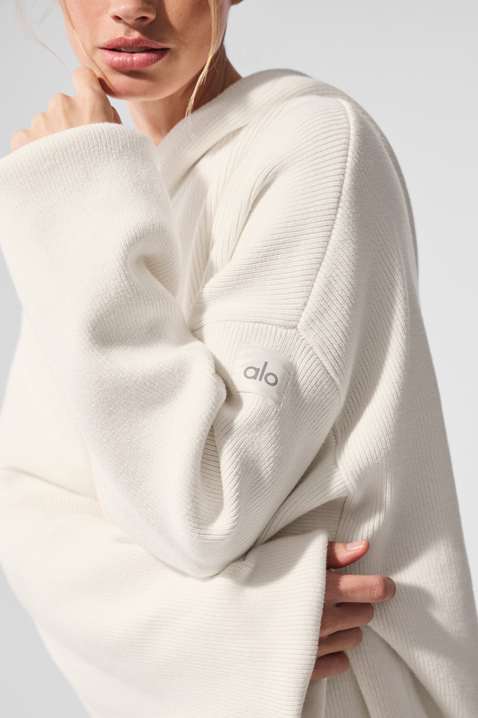 Close-up of the ivory knitted hoodie fabric showing soft texture