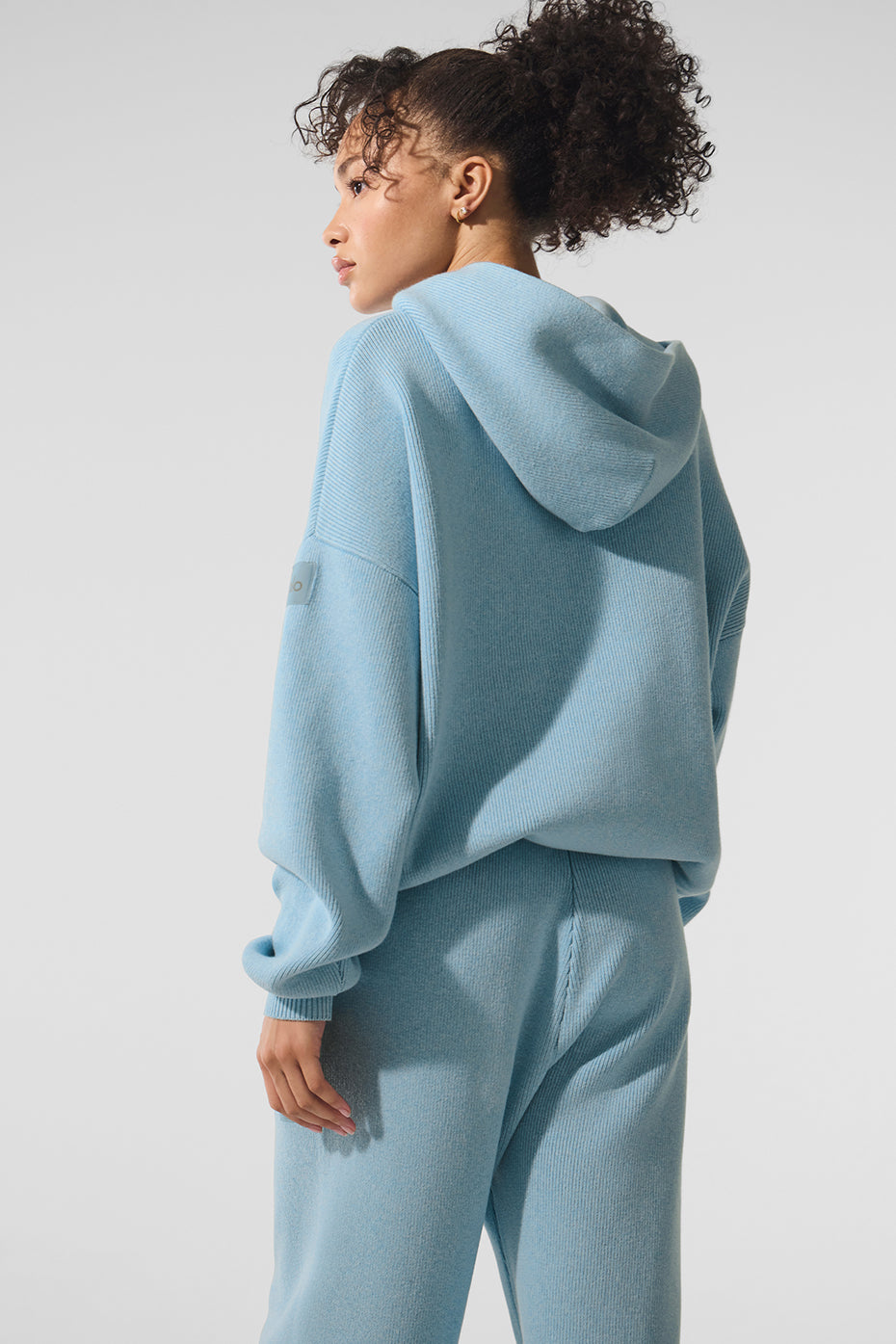 Back profile of light blue hoodie worn on a casual morning coffee run