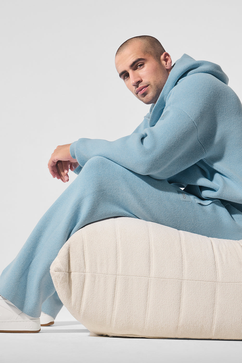 Unisex hoodie laid flat showing built-in hood and textured knit yarn