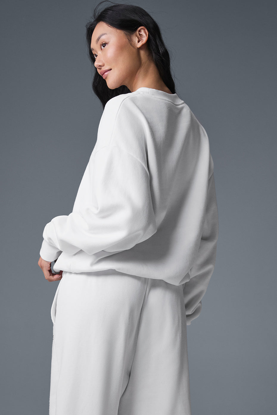 Model wearing the white cable knit sweater, styled with casual jeans.