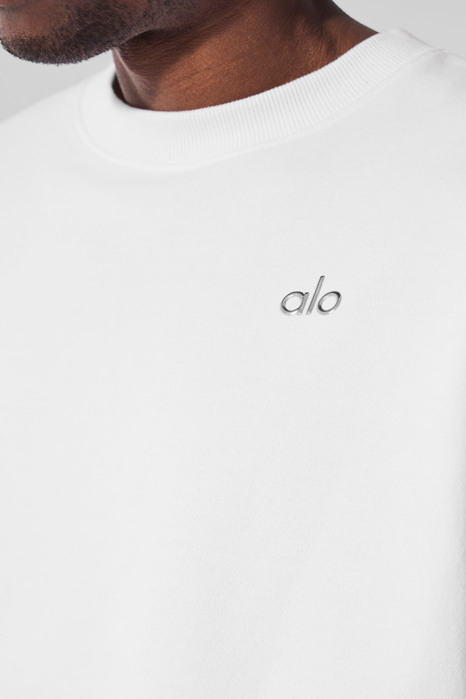 Side angle of the white crew neck pullover showcasing the relaxed fit.