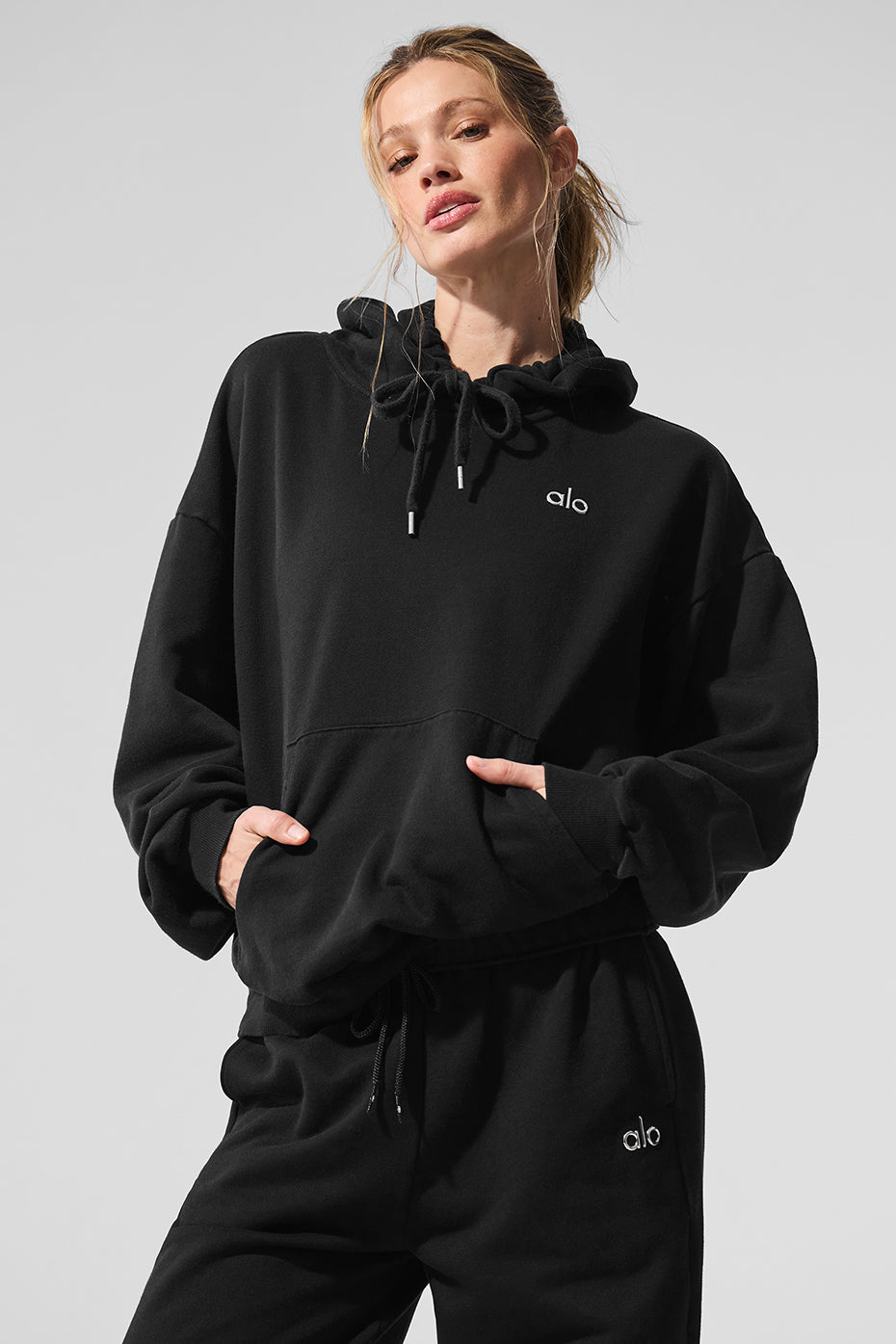Model wearing the Accolade hoodie in an urban street setting