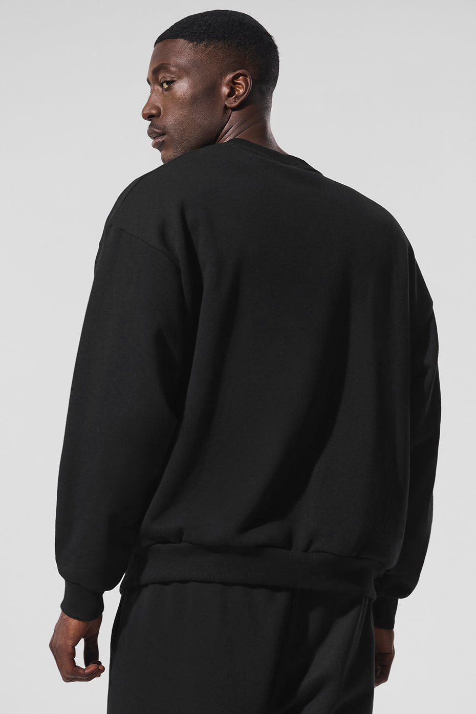 Casual outfit featuring black crew neck pullover with matching sweatpants.