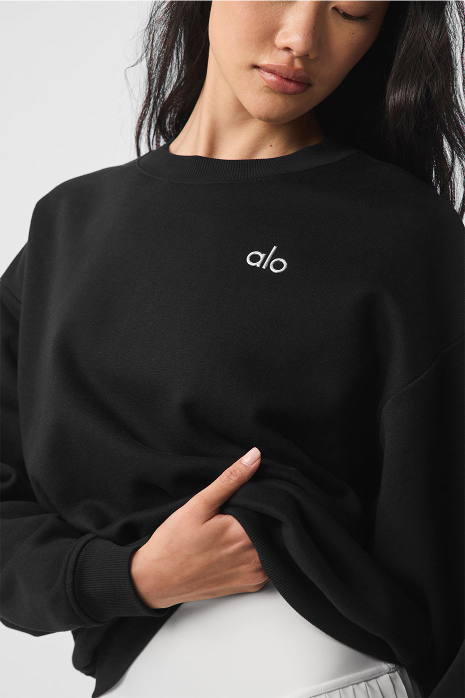 Close-up of the ribbed cuffs and hem of the black sweatshirt.