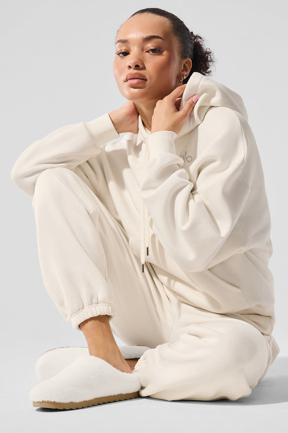 Model wearing ivory hoodie with relaxed fit, styled with neutral-toned joggers