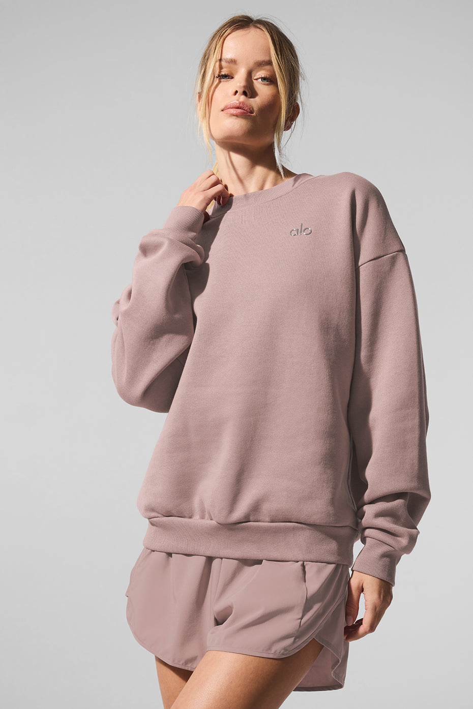 Side angle of the womens black sweatshirt, highlighting the ribbed cuffs and hem.