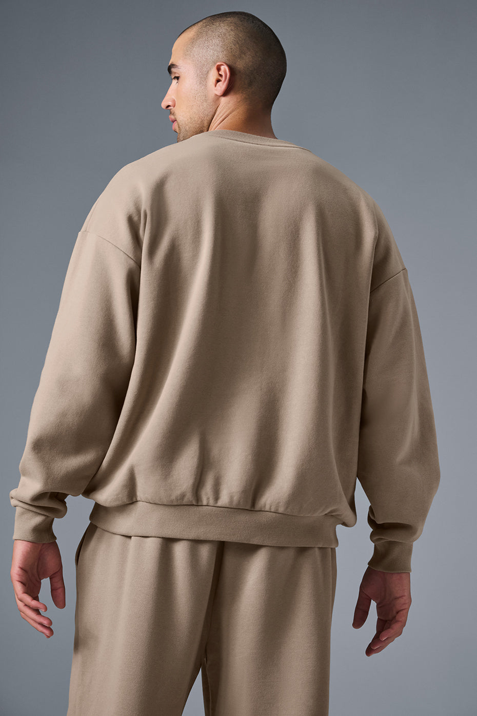 Model wearing the French terry sweatshirt with layered streetwear in an urban setting.