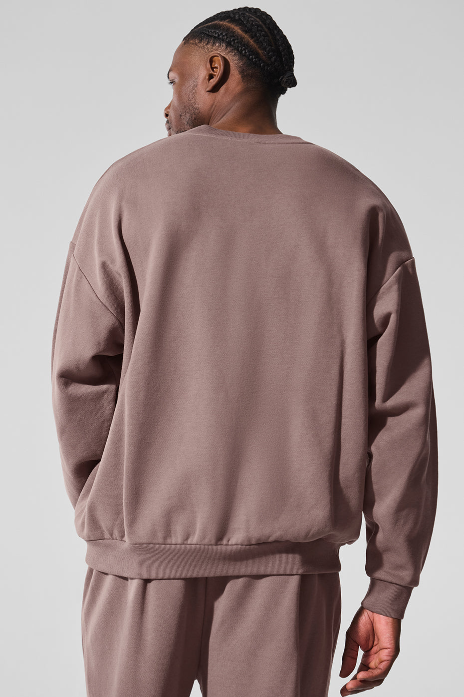 Side view of the black crew neck pullover, highlighting the ribbed cuffs and hem.