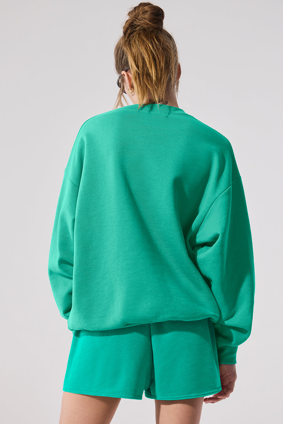 Front view of the dark green hooded sweatshirt showcasing its relaxed fit.