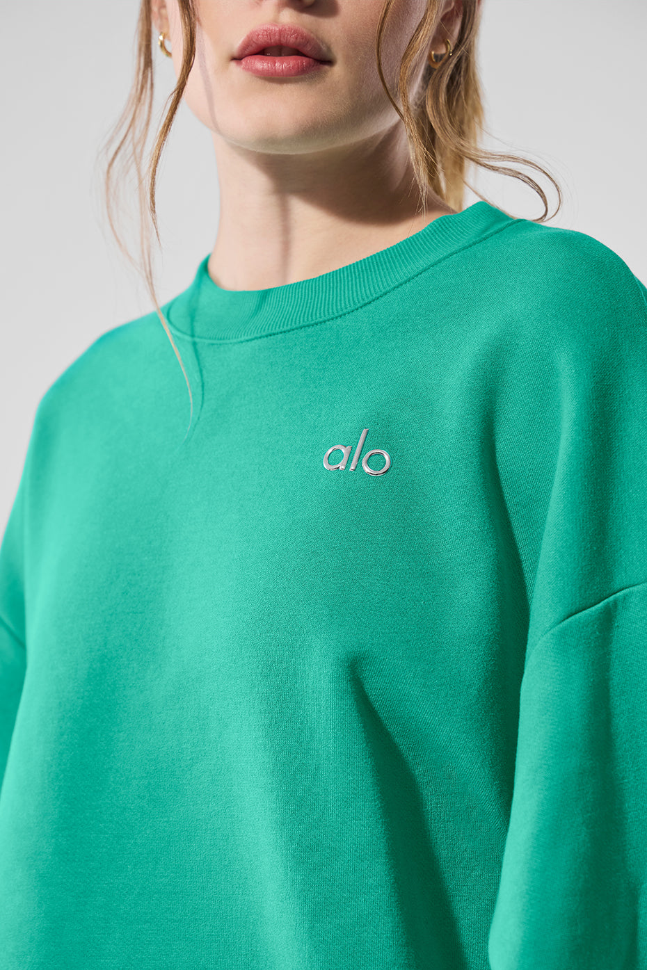 Model wearing a kelly green sweatshirt styled with jeans for a casual outing.