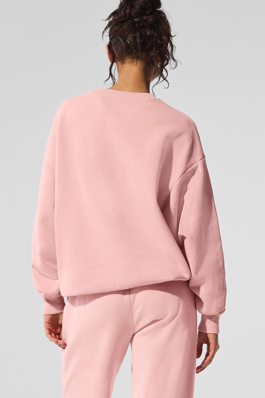 Front view of the pink quartz Accolade crew neck pullover, showcasing its relaxed fit.