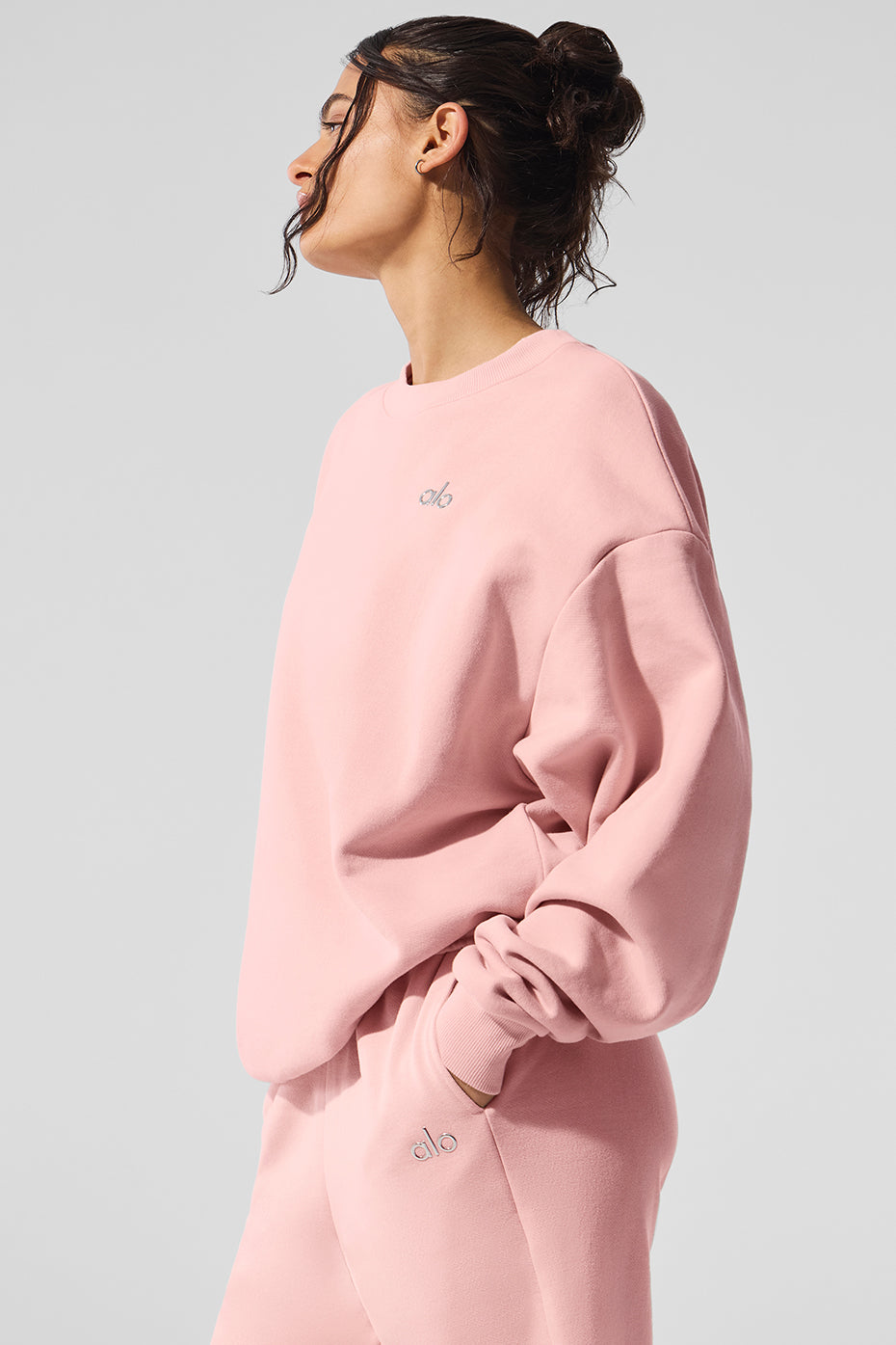 Lifestyle shot of a model wearing the Victoria Secret pink sweatshirt, styled with jeans.