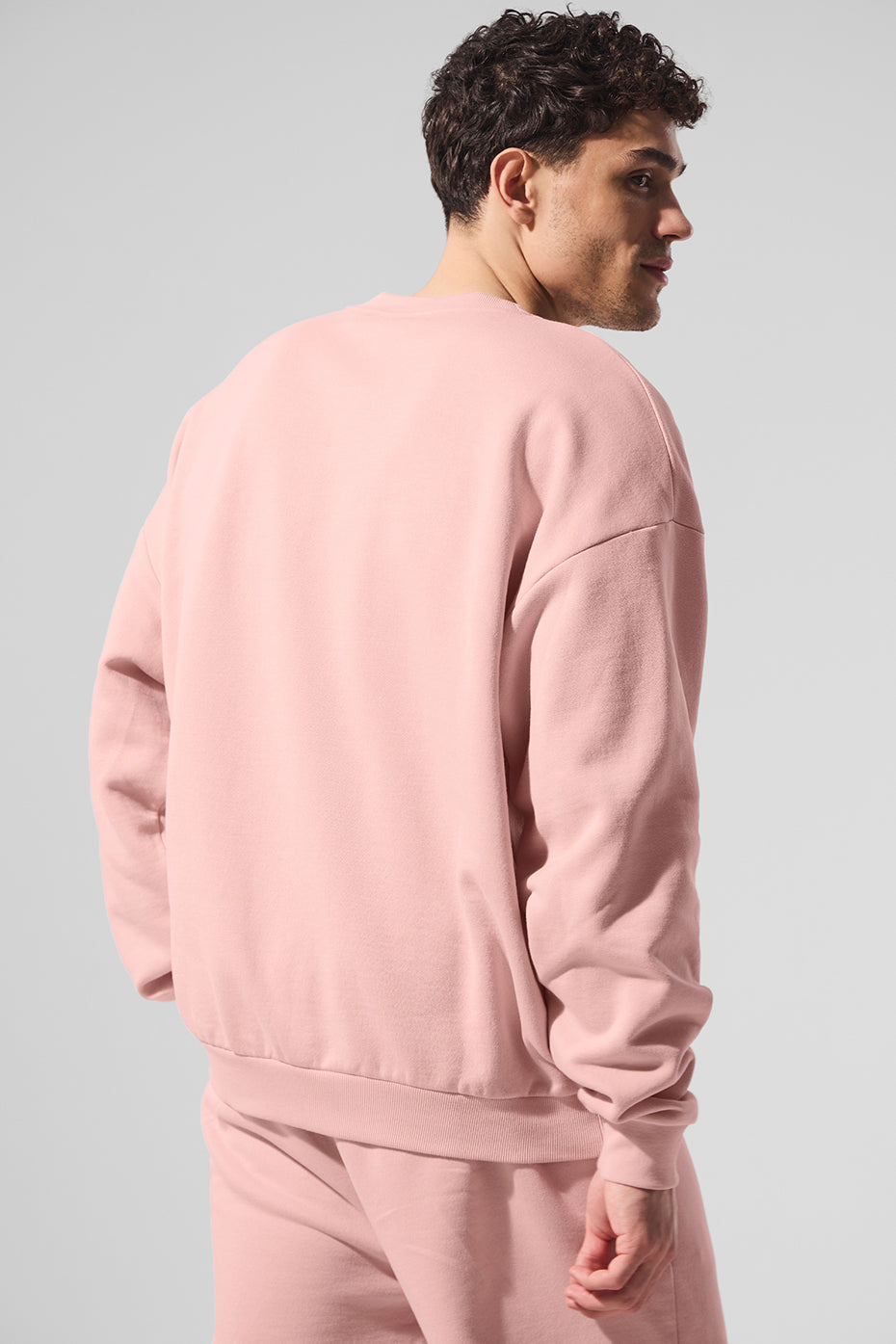 Close-up of pink quartz crew neck pullover showing ribbed cuffs and neckline