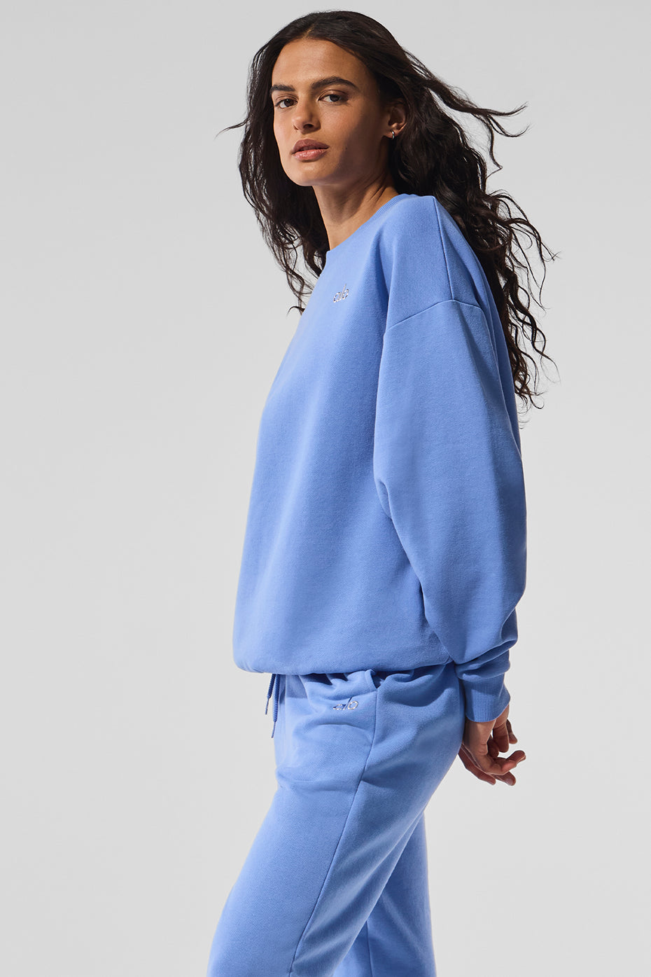 Model wearing navy blue hooded sweatshirt with layered styling