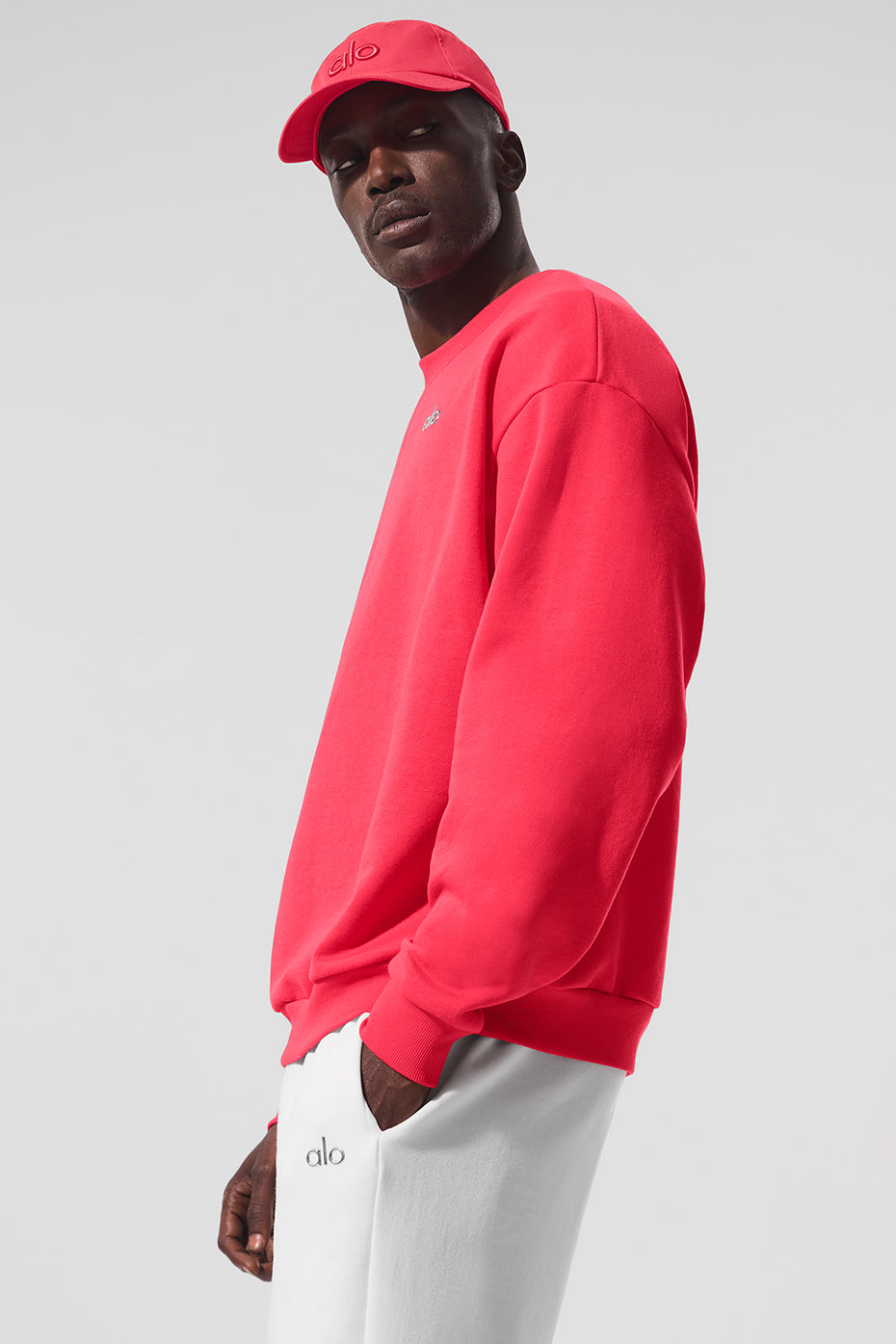 Close-up of the Acclaimed Crew Neck Pullover in vibrant red, showcasing the ALO logo.