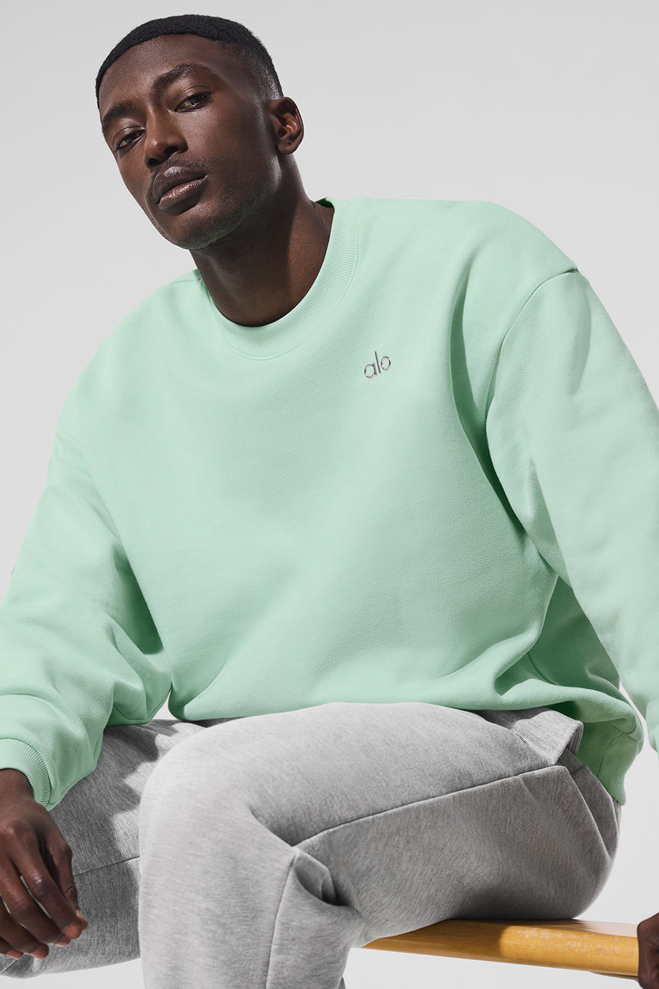 Front view of the spearmint Accolade crew neck pullover styled with jeans.