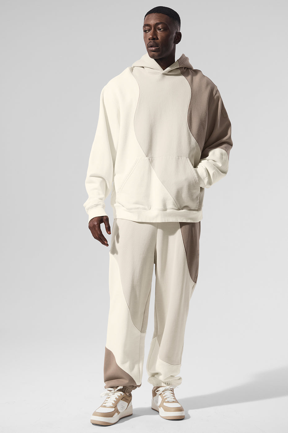 Model wearing oversized hoodie with hood up on a breezy San Francisco street