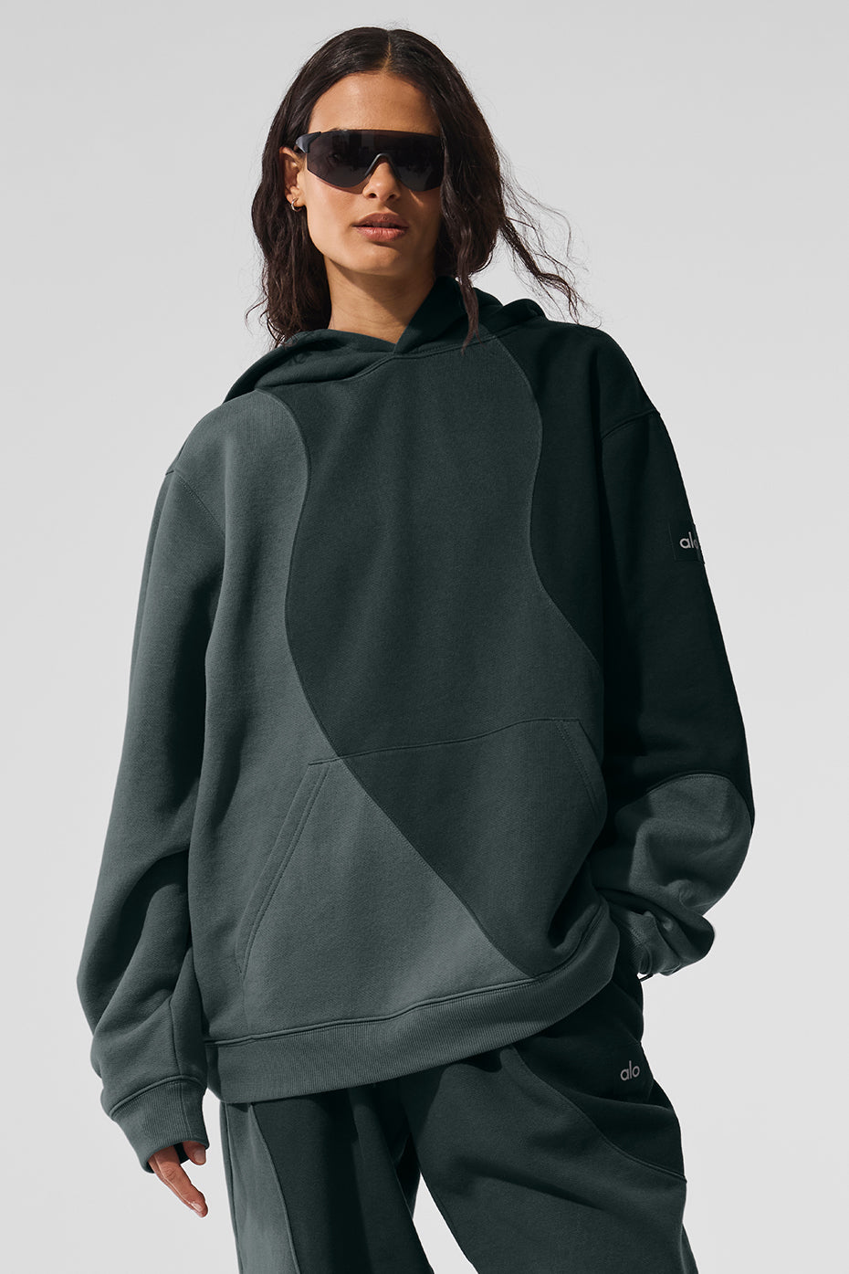 Front view of the charcoal green oversized hoodie styled with sweatpants.