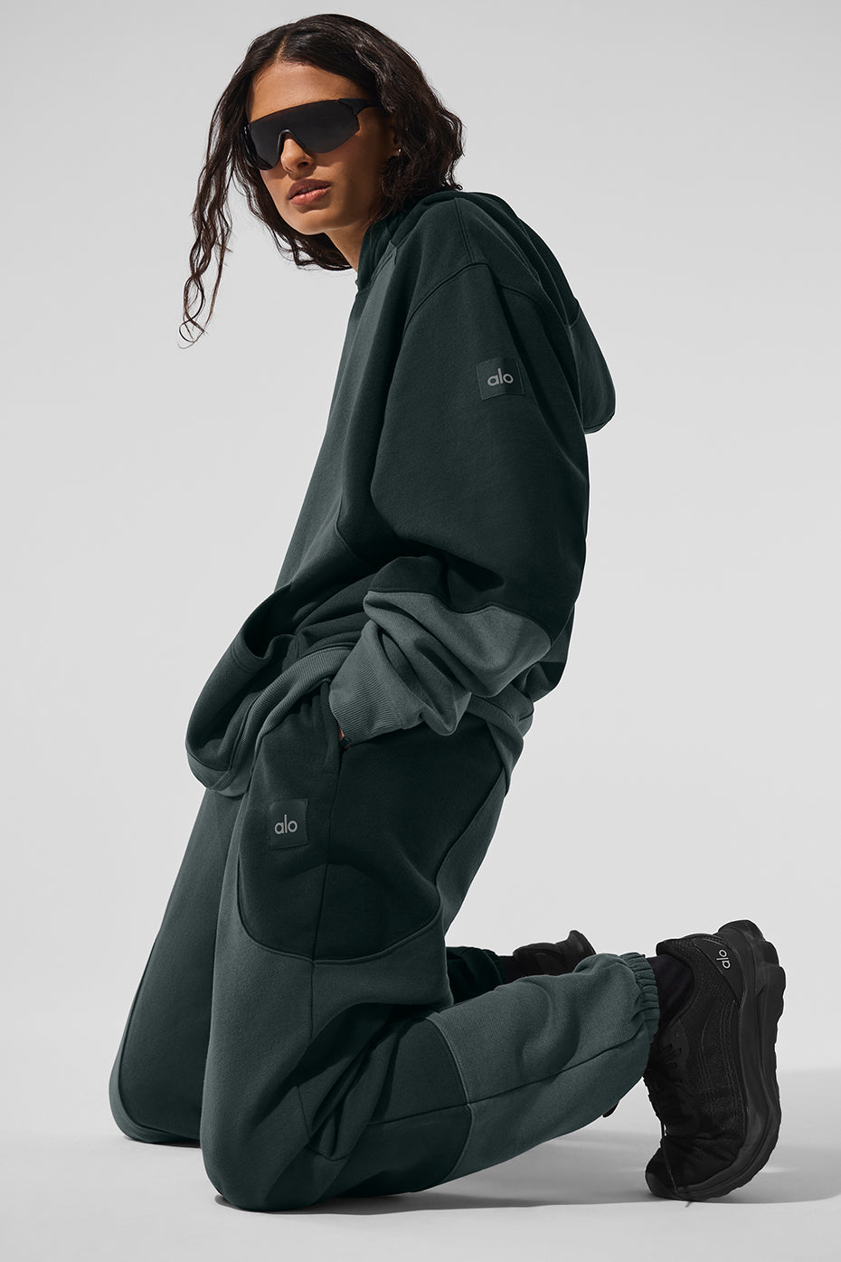Front view of the charcoal green oversized hoodie styled with sweatpants.