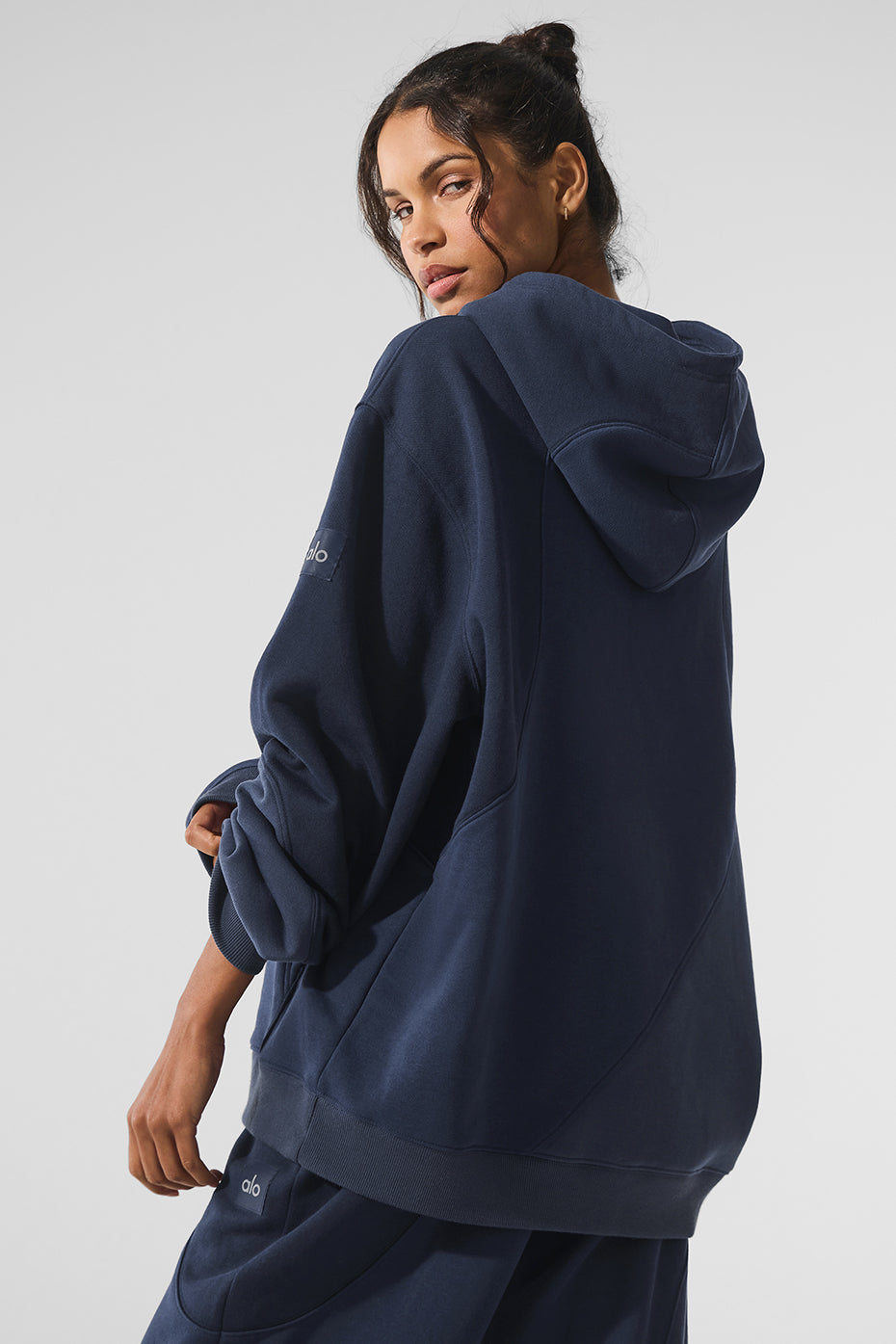 Model wearing oversized hoodie with wave detail in urban setting