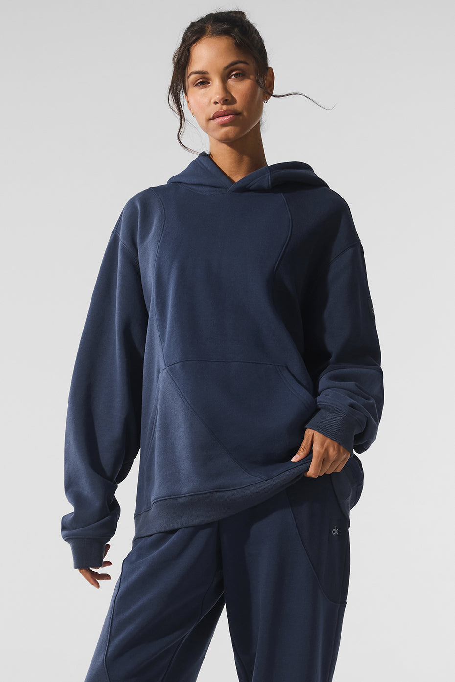 Model wearing oversized hoodie with wave detail in urban setting