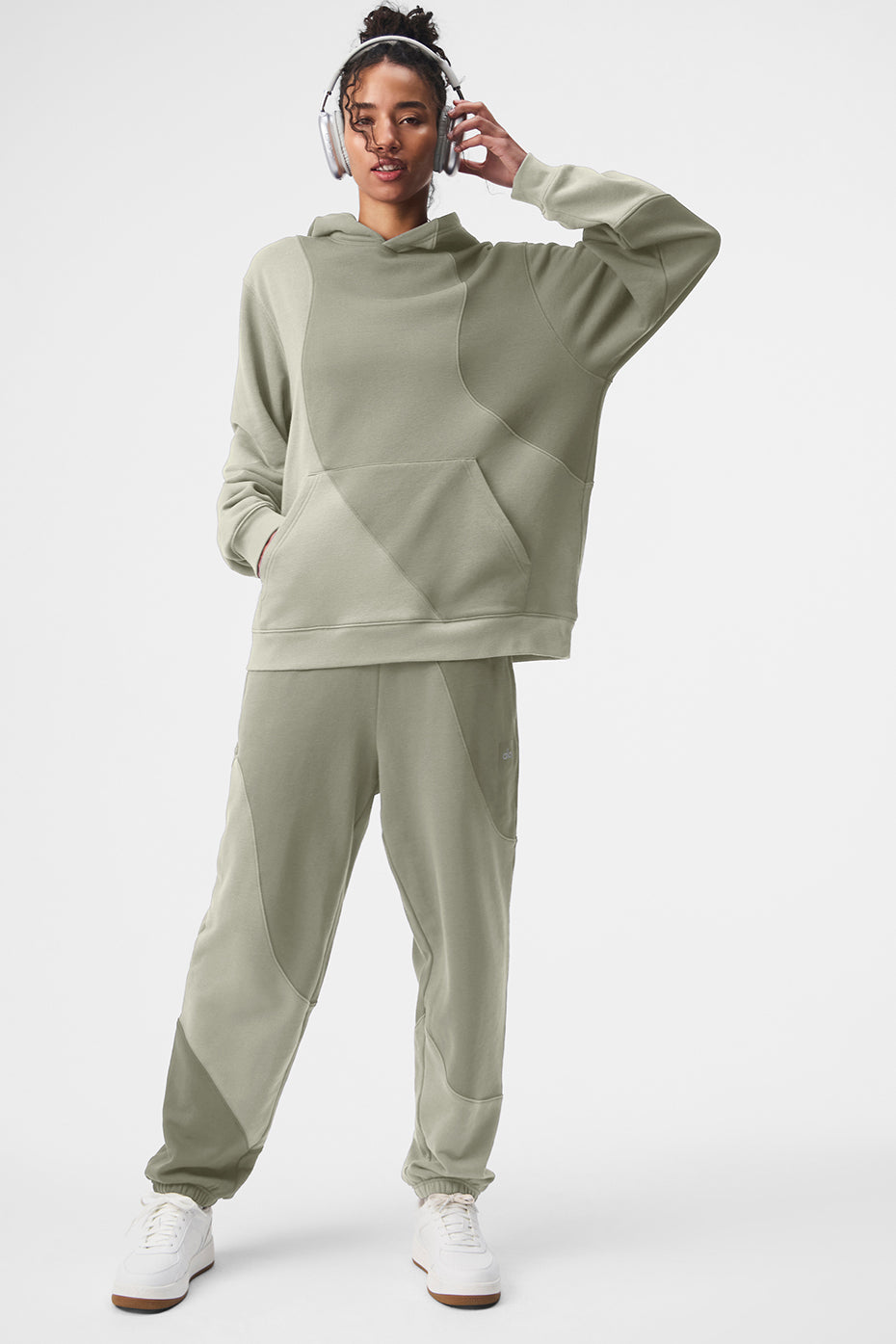 Model lounging outdoors in oversized zip up hoodie styled with matching sweats
