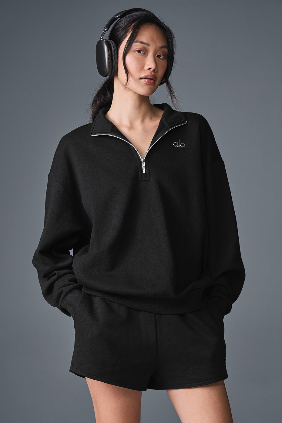 Model walking downtown in black crew neck pullover styled with chinos