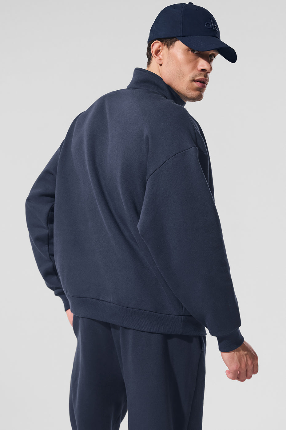 Stylish mens quarter zip pullover layered with a shirt in a relaxed setting