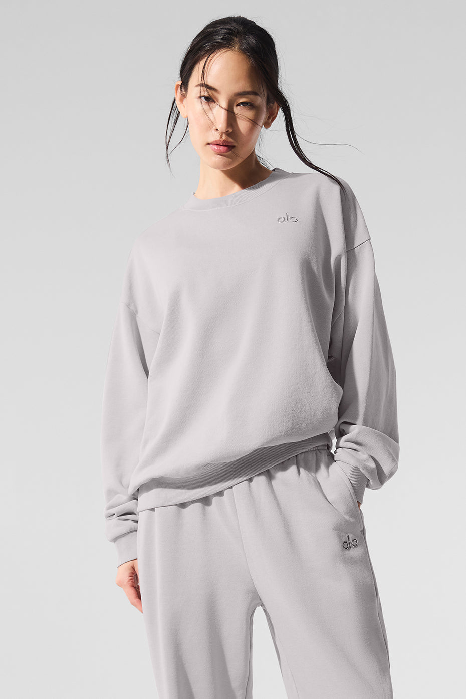 Front view of the washed grey sky women's crew neck pullover styled with leggings for casual wear