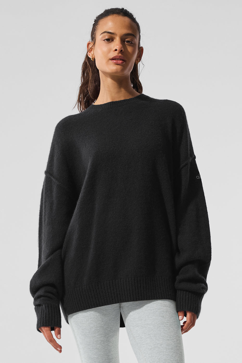 Front angle of black crewneck cashmere sweater on male model outdoors