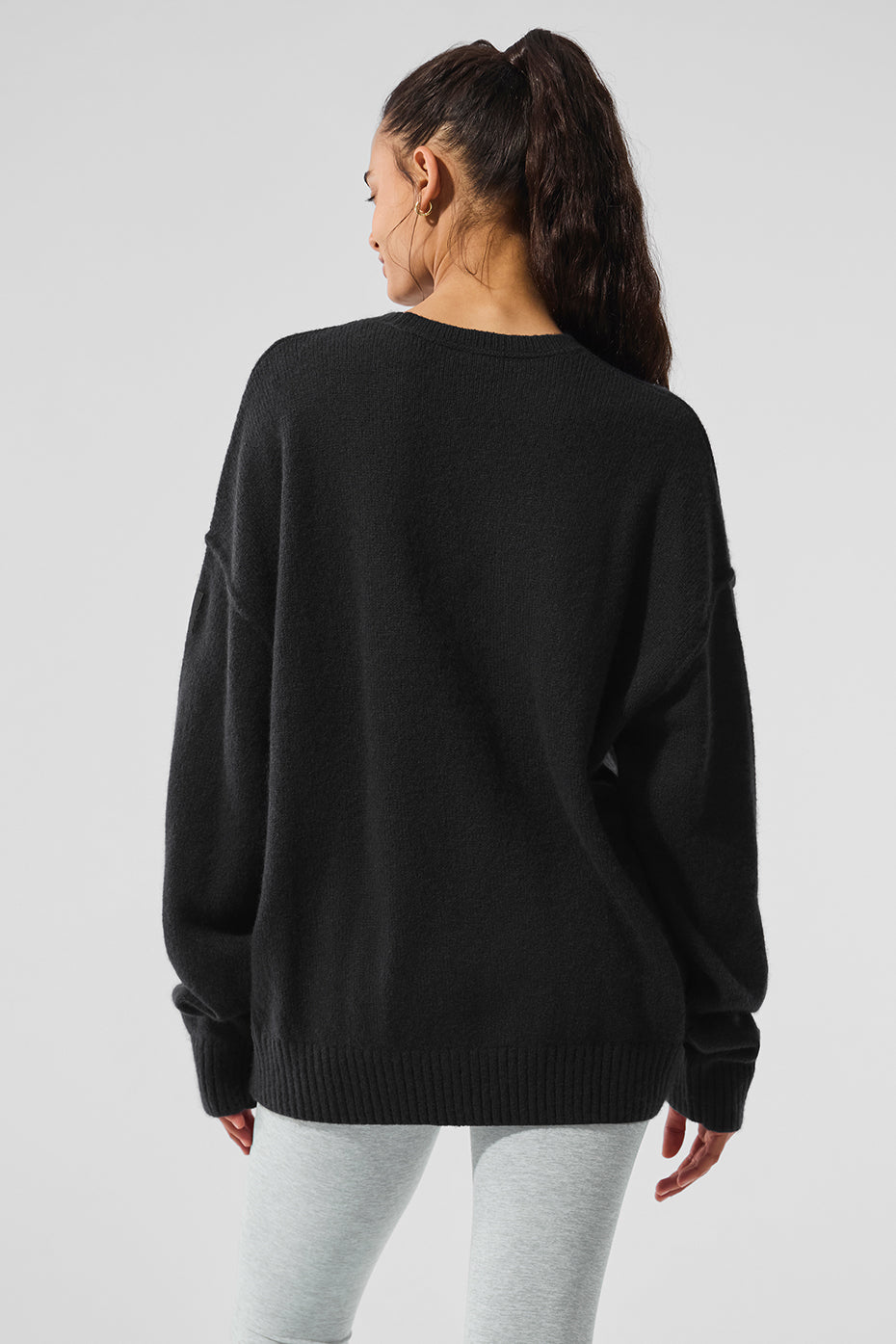 Back view of relaxed-fit cashmere cardigan sweater worn over shirt