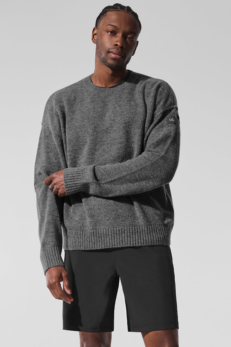 Platinum grey cashmere crewneck sweater displayed on a model outdoors.