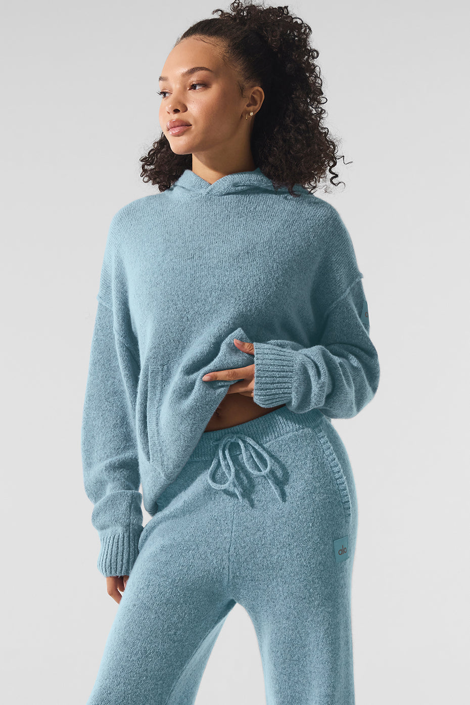 Woman wearing cashmere zip hoodie with coffee mug in hand