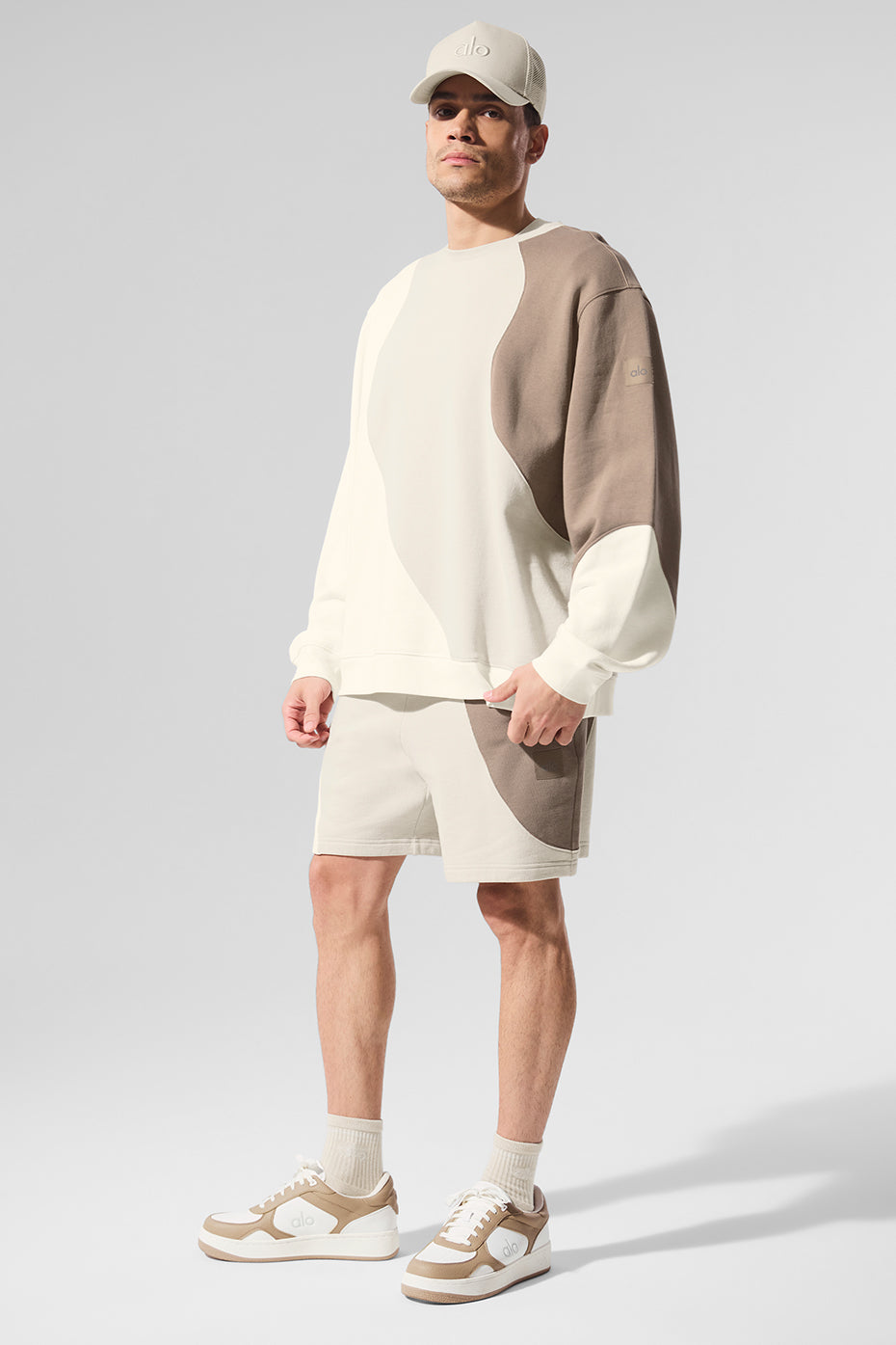 Woman wearing an oversized sweatshirt, smiling with arms crossed for a cozy look.