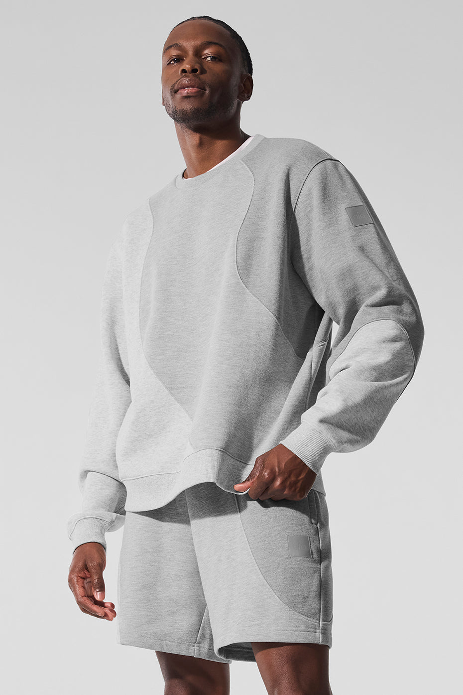 Front view of black crew neck pullover styled with matching sweatpants